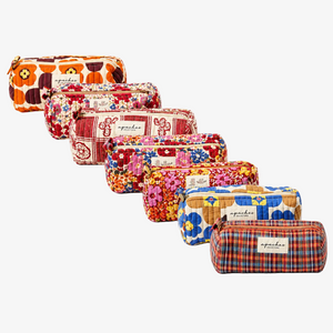 Seven quilted zip pouches in various colorful floral and plaid patterns, arranged diagonally on a plain white background. Each pouch features a small white label with the brand name 'apdaku' printed on it.