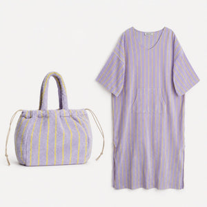 Purple and yellow striped dress and bag on a white background