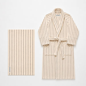 Beige striped robe and towel set on a white background
