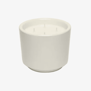 An off-white ceramic vessel candle with three wicks, shown on a clean white background.