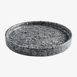 A round granite serving tray with a textured, speckled dark gray and black pattern, shown on a clean white background.